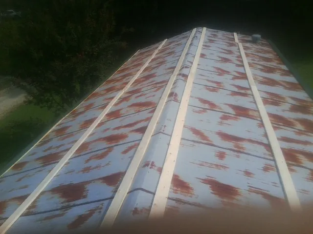 Rusted metal roof panels with new wood purlins before replacement — Storm Damage Roof Repair in Smiths Grove by Roofing Brothers