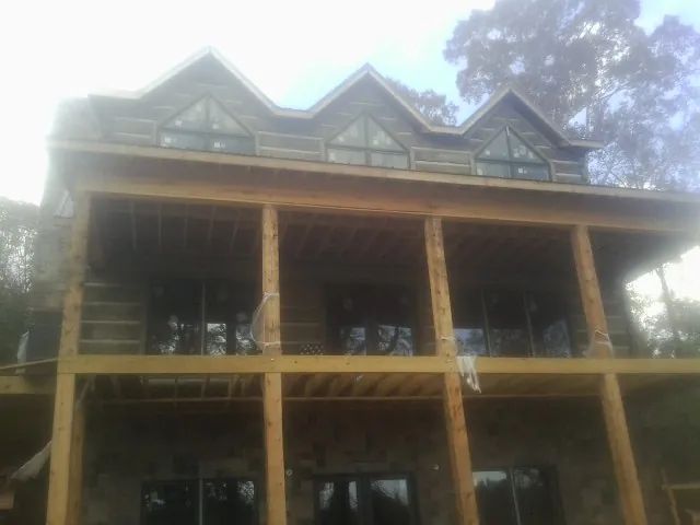 Dormers and porch framing on a large log home under construction — Roof Coating work by our crew in Smiths Grove